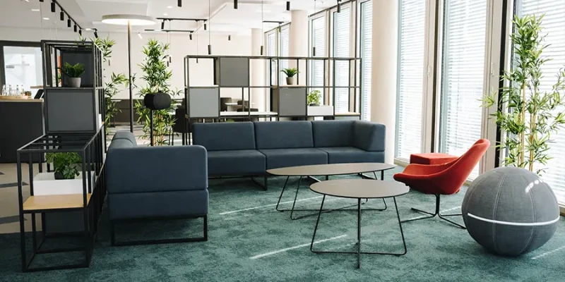 Ein Büro mit Schreibtischen, Schreibtischstühlen, Tischtrennwänden Raumteilern und Deckensegeln