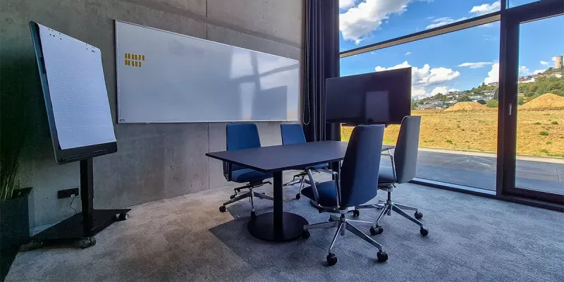 Kleiner Seminarraum mit großem Whiteboard, Flipchart und Bildschirm