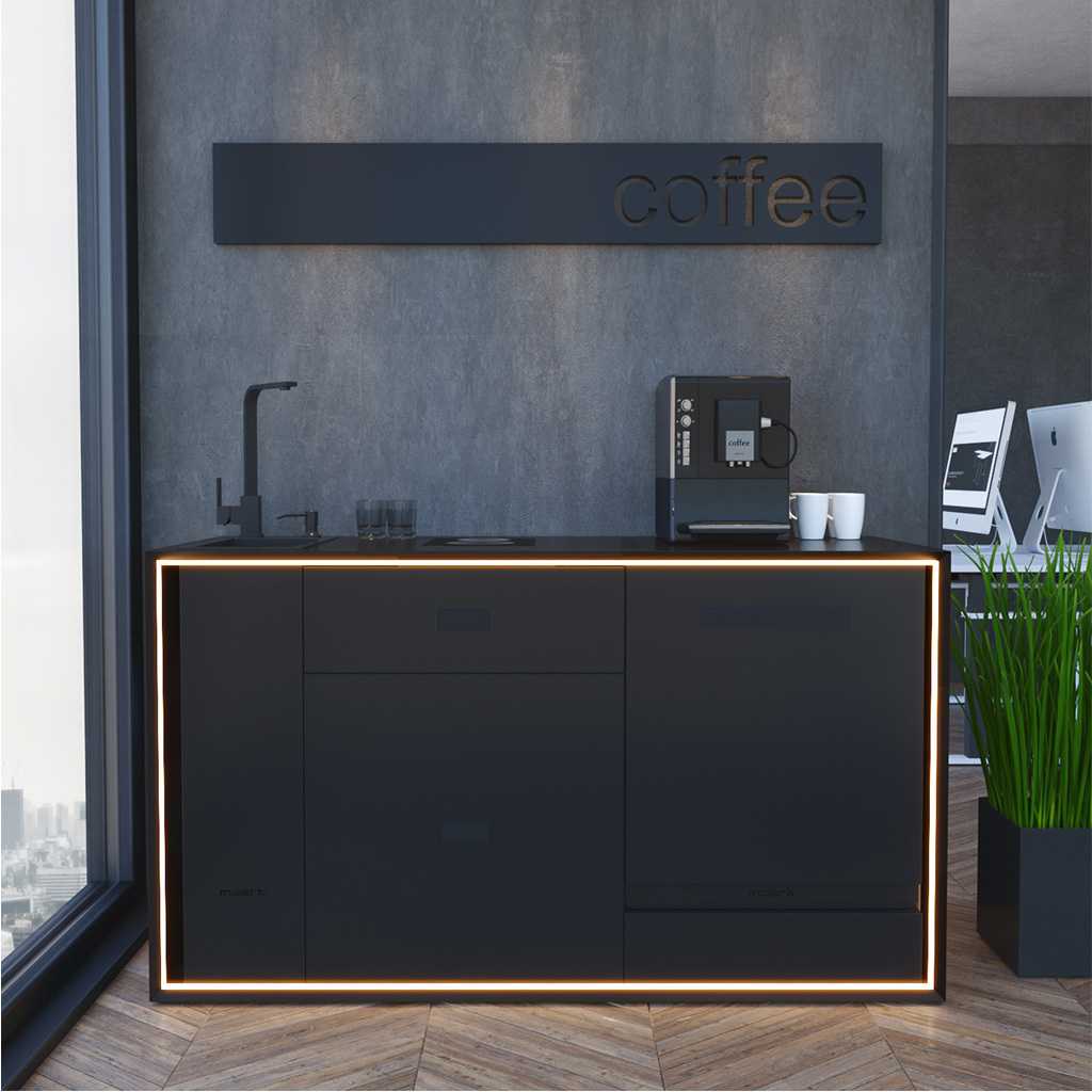 moderne Büroküchenblöcke und Büroküchenzeilen offene Küche im Büro, zweizeilig mit Spülbecken. Auf der Arbeitsfläche steht ein Kaffeevollautomat. Neben der Küchenzeile steht eine Kunstpflanze, dahinter zwei Monitore auf einem Schreibtisch.