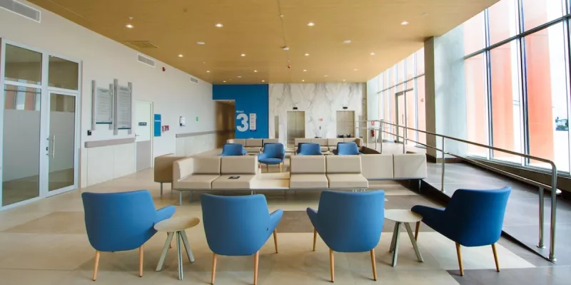 Wartezimmer in Klinik mit Rollstuhlrampe und Loungemöbeln in Blau und Creme