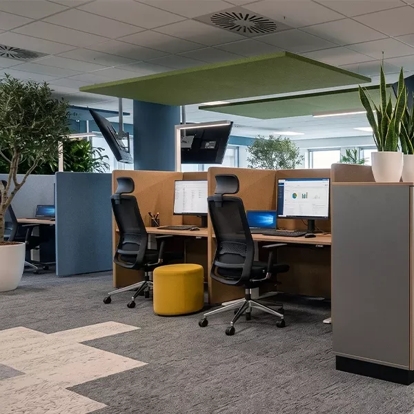 Arbeitsplätze im Großraumbüro mit Akustikelementen um und über den Plätzen
