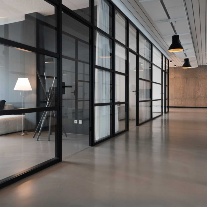 Großer Büroflur mit Glastrennwänden im Loft-Style
