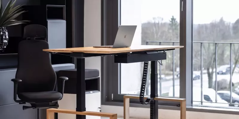 Höhenverstellbarer Chefschreibtisch mit Holz und modularem Stauraum im Hintergrund
