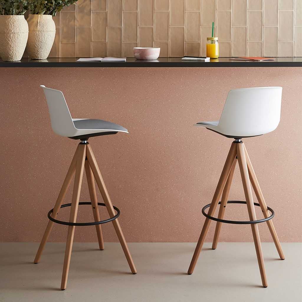 Vierfuß Barhocker mit Holzbeinen Zwei Bahrhocker mit einem Holz-Vierfuß vor einer Theke
