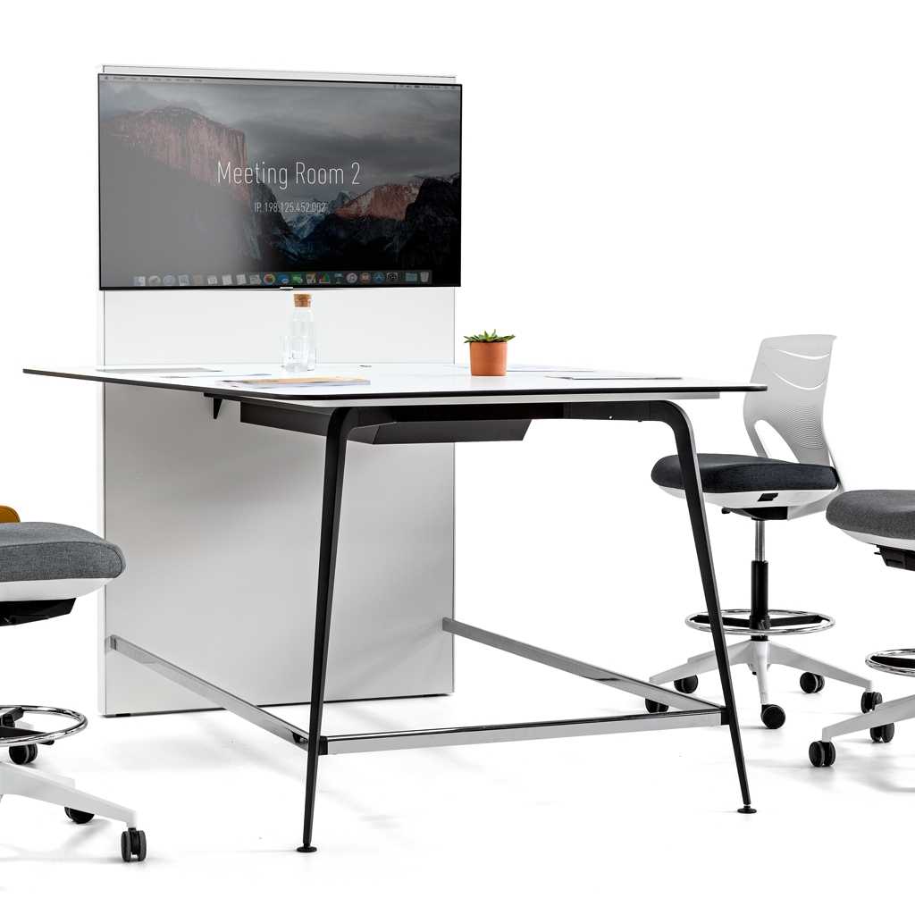 kleiner Konferenztisch Kleiner Konferneztisch. Weiße Platte mit schwarzem Metallgestell. An der Stirnseite eine Displaywand mit Monitor. Um den hohen Tisch stehen drei Counterdrehstühle mit Rollen in weiß mit schwarzem Sitzpolster.