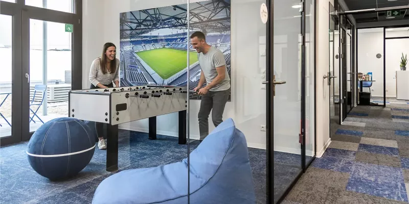 Abgetrennte Bürolounge mit Sitzbällen, Sitzkissen und Tischkicker